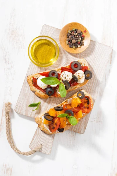 Italian appetizer - bruschetta on wooden board, top view — Stock Photo, Image