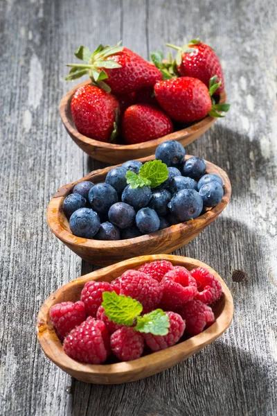Assortment of fresh seasonal berries in a wooden bowl, vertical — Stock Photo, Image