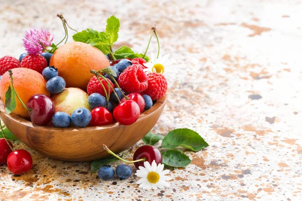 Kom met seizoensgebonden fruit en bessen op tafel, close-up — Stockfoto