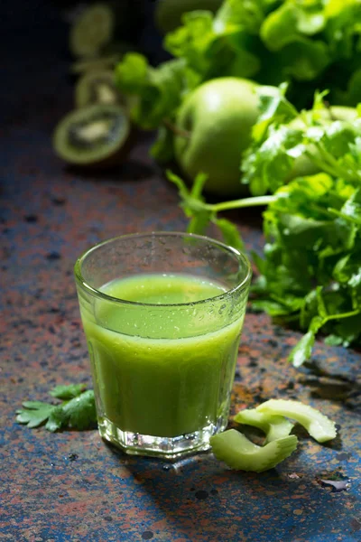 Glas juice av selleri och gröna på blå bakgrund, vertikal — Stockfoto