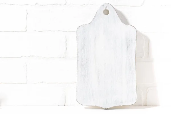 Placa de corte de madeira branca, fundo de tijolo — Fotografia de Stock