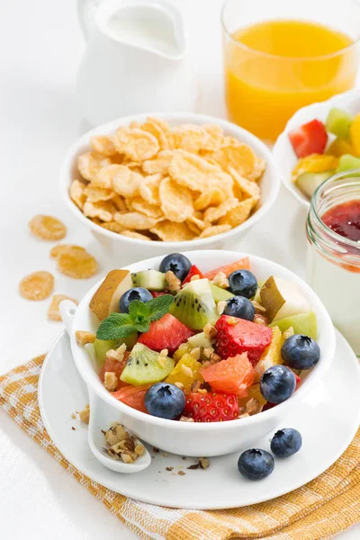 Breakfast with fruit salad and corn flakes on white table — Stock Photo, Image