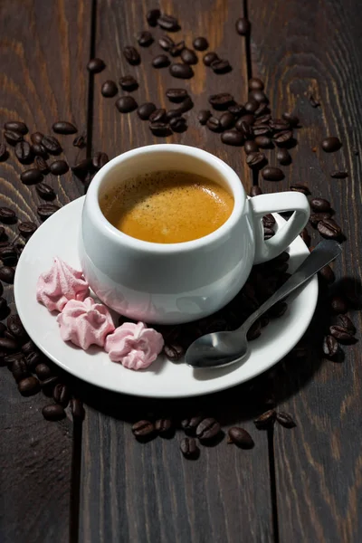 Tazza di espresso e meringhe rosa su sfondo di legno scuro — Foto Stock