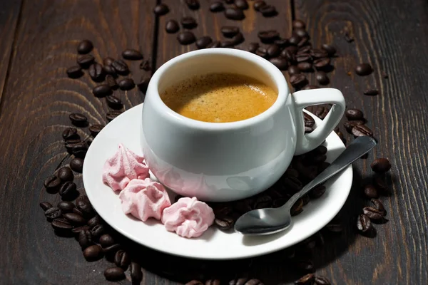Kopp espresso och rosa maränger på trä bakgrund — Stockfoto