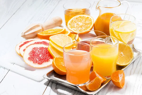 Fresh citrus juices on white table — Stock Photo, Image