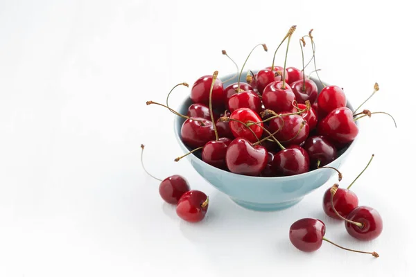 Tigela de cerejas frescas em um fundo branco, vista superior — Fotografia de Stock