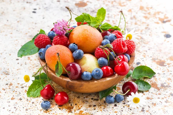 Kom met seizoensgebonden fruit en bessen, close-up bovenaanzicht — Stockfoto