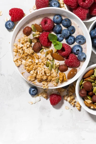 Мюслі з йогуртом та ягодами на сніданок на білому тлі — стокове фото