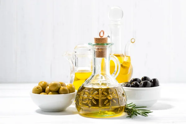 Botella con aceite de oliva y cuencos con aceitunas — Foto de Stock
