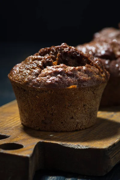 Muffins au chocolat sur une planche de bois, gros plan vertical — Photo