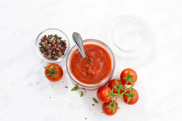 Molho de tomate em um frasco de vidro e fundo branco, vista superior — Fotografia de Stock