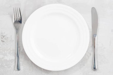 Konsept fotoğraf. Beyaz boş tabak ve çatal bıçak takımı, portre
