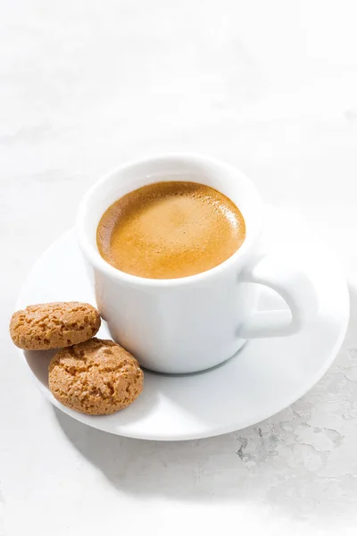 Xícara de café expresso e biscoitos de amêndoa em uma mesa branca, vertical — Fotografia de Stock