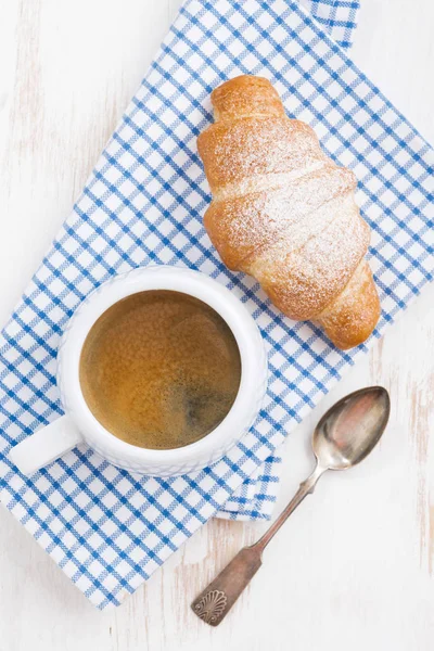 Espresso und frisches Croissant, vertikal, Nahaufnahme — Stockfoto