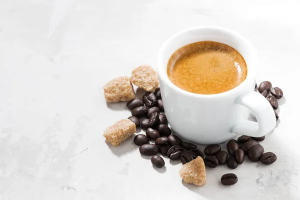 Tazza di caffè espresso e zucchero su un tavolo bianco, primo piano — Foto Stock