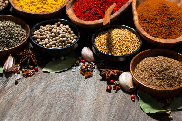 assortment of various spices on a wooden table, closeup