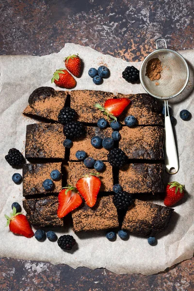 El postre - los brownies de chocolate con las bayas frescas, vertical —  Fotos de Stock