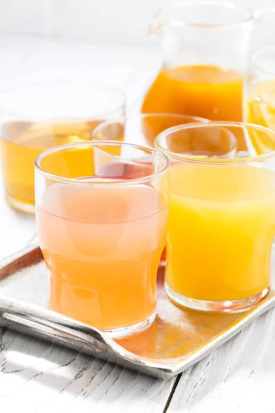 Fresh citrus juices in assortment, vertical closeup — Stock Photo, Image