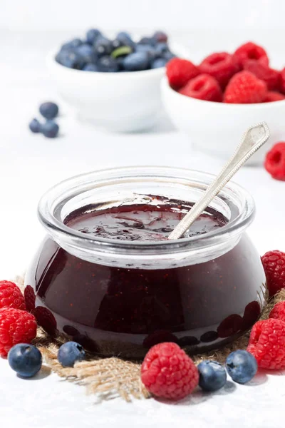 Confiture de framboises et de bleuets dans un bocal en verre, gros plan vertical — Photo