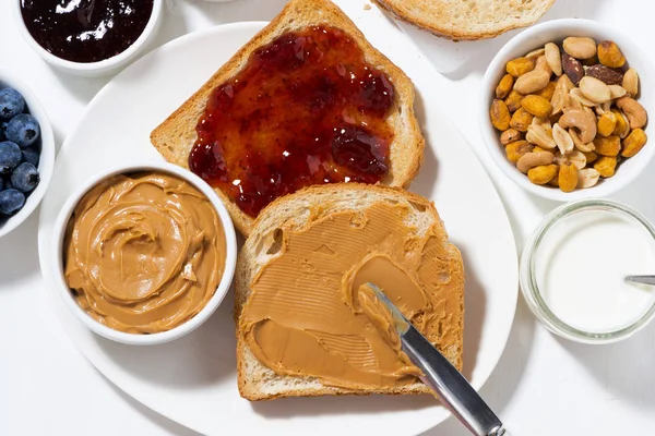Toast with peanut butter and jam for breakfast, top view — Stock Photo, Image