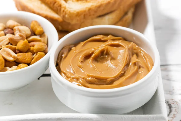 Manteiga de amendoim e torradas para o café da manhã, close-up — Fotografia de Stock