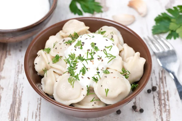 Traditional dumplings with sour cream and dill, top view — Stock Photo, Image