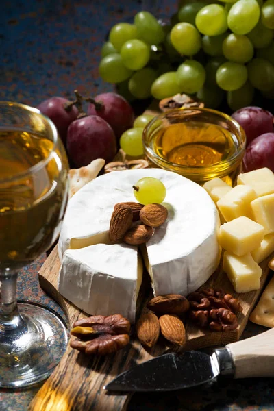 Spuntini, vino e formaggio Camembert su sfondo scuro, verticale — Foto Stock