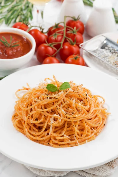 Pasta con salsa de tomate en un plato e ingredientes, vertical — Foto de Stock