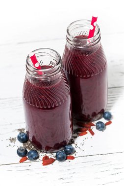 Beyaz arka planda, dikey kavanozlara sağlıklı berry güler yüzlü