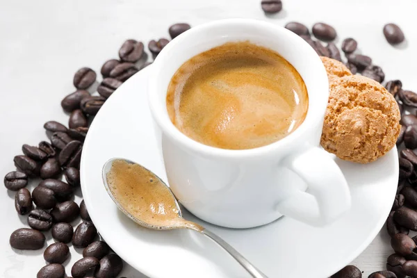 Xícara de café expresso fresco e biscoitos em um fundo branco, close-up — Fotografia de Stock