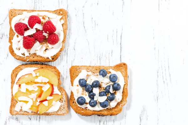 Sladké toasty s různými polevami na bílý dřevěný stůl — Stock fotografie