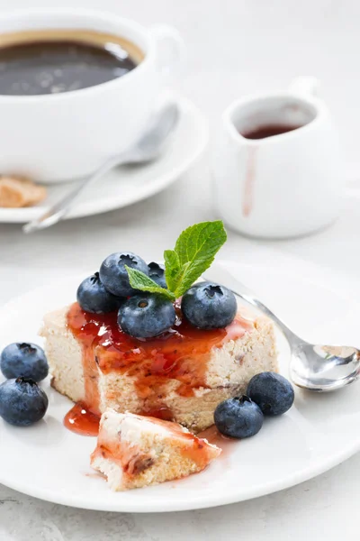 Pedaço de cheesecake com geléia de baga e xícara de café, vertical — Fotografia de Stock