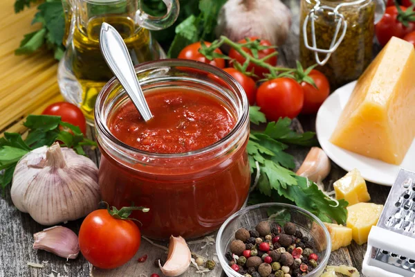 Molho de tomate em um frasco de vidro e ingredientes — Fotografia de Stock