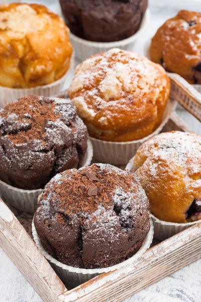 Delicious muffins on a wooden tray, vertical, top view — Stock Photo, Image