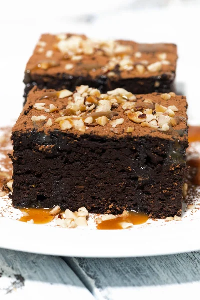 El postre - los pedazos de los brownies de chocolate con la salsa de caramelo —  Fotos de Stock