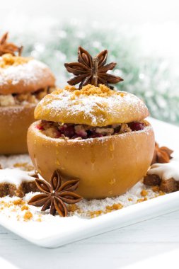 şenlikli pişmiş doldurulmuş elma ve gingerbread beyaz plaka üzerinde