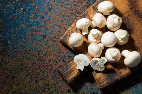 Fresh organic mushrooms on vintage cutting board, top view — Stock Photo, Image
