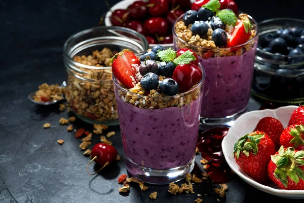 Hälsosamma blåbär med müsli och bär på en mörk bakgrund — Stockfoto