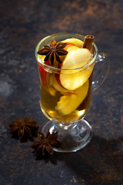 glass of hot apple tea with spices, vertical