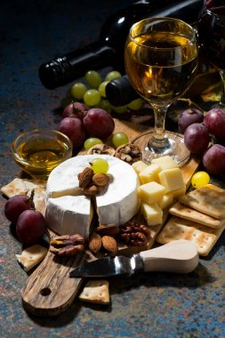 atıştırmalıklar, şarap ve karanlık bir arka plan, dikey Camembert peyniri