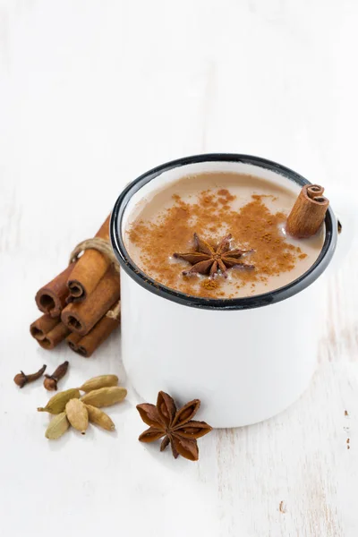 Té Masala en una taza y los ingredientes en la mesa blanca, vertical —  Fotos de Stock