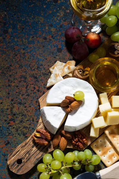 Snacks, Wein und Camembert und dunkler Hintergrund, vertikal — Stockfoto