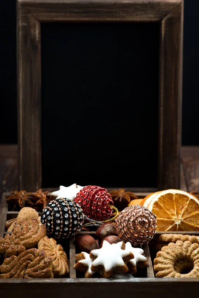 Caja de madera con dulces navideños, especias y fondo oscuro — Foto de Stock