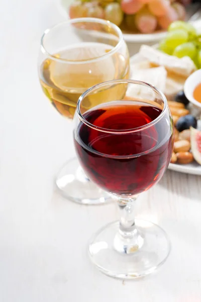 Copos com vinho e lanches na mesa branca, vertical — Fotografia de Stock