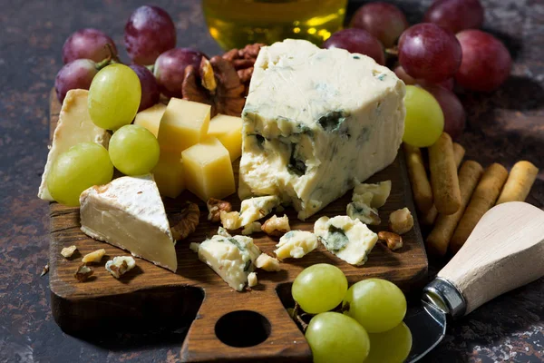 Ostbricka, färsk frukt och honung på ett mörkt bord, närbild — Stockfoto