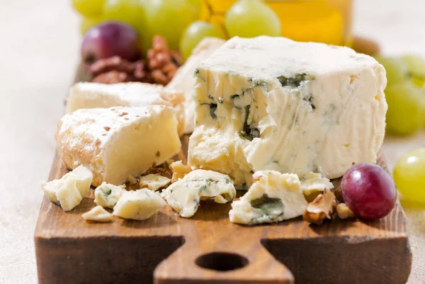 Tabla de quesos, frutas y miel en la mesa blanca —  Fotos de Stock