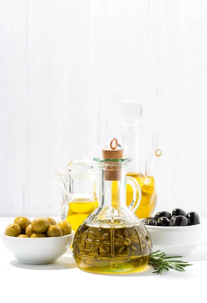 Bottle with olive oil and bowls with olives, vertical — Stock Photo, Image