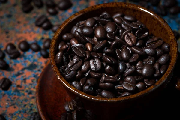 Dark cup with coffee beans, closeup — Stock Photo, Image