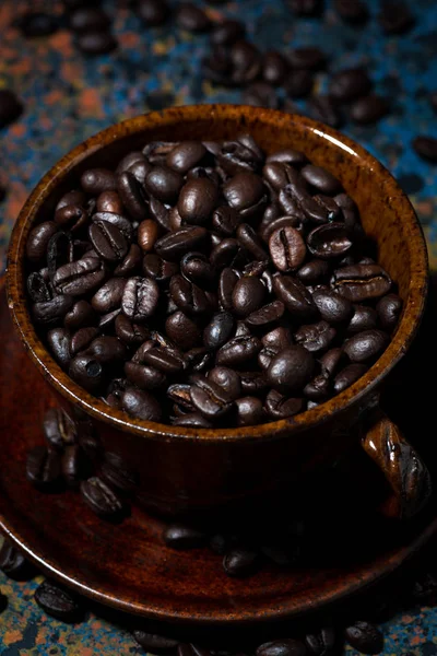 Dark cup with coffee beans, vertical top view — Stock Photo, Image