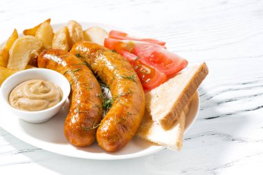 patates ve plaka üzerinde hardal ile kızarmış domuz sosisi
